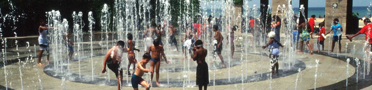 Children play in a splash pad fountain.